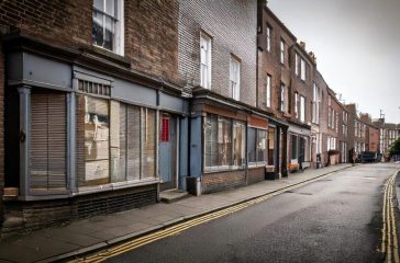 Firefly-grey-poor-british-high-street-with-boarded-up-shops-97323-scaled