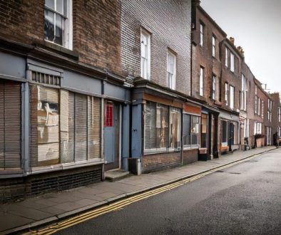 Firefly-grey-poor-british-high-street-with-boarded-up-shops-97323-scaled